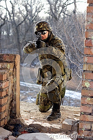 Soldier sitting near wall with a gun Stock Photo