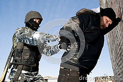 Soldier taking a criminal under arrest Stock Photo