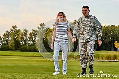 Soldier walking with wife holding hands. Stock Photo