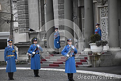 Soldiers in ceremonial blue uniforms with rifles stand quietly in front of the Serbian presidency building Editorial Stock Photo