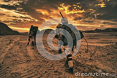 Soldiers walking on in the wilderness in the sunset Stock Photo