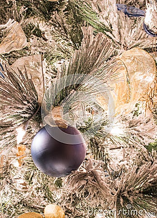 A solid blue Christmas ornament on a flocked Christmas tree Stock Photo