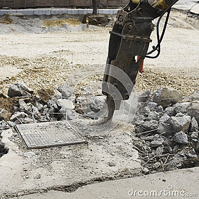 A solid body hammer and hydraulic breaker for asphalt, skid steers, backhoe-loaders and excavators. The machine for construction a Stock Photo