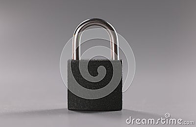 Solid metal locked padlock on grey background, thing to protect home or apartment Stock Photo