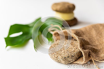 Solid shampoo disc close up with green natural leaf and jute bag example of natural and ecological plastic free cosmetic, homemade Stock Photo
