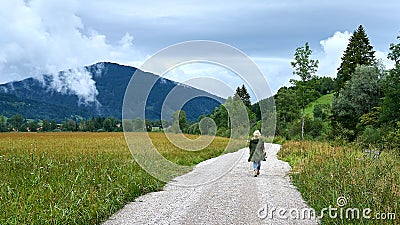 Solitary Blonde Female Walking a lonely path in the Bavarian Countryside Editorial Stock Photo