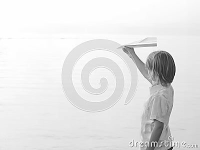 Solitary boy playing with his toy airplane Paper Stock Photo