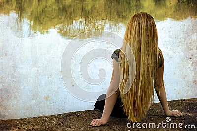 Solitude - lonely woman sitting on lake side Stock Photo