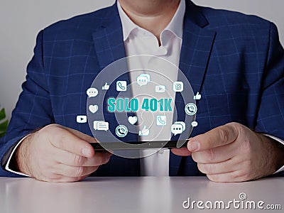 SOLO 401K inscription on the screen. Close up Merchant hands holding black smart phone Stock Photo