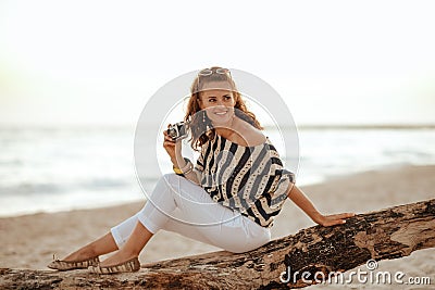 Solo traveller woman with retro film photo camera looking aside Stock Photo