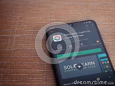 SoloLearn - Learning coding app play store page on the display of a black mobile smartphone on wooden background Editorial Stock Photo