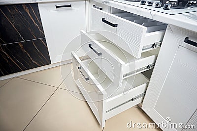 Solution for placing kitchen utensils in modern kitchen - horizontal sliding pullout drawer shelves storage in cupboard for Stock Photo