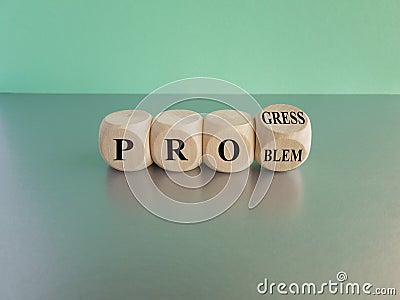Solving a problem and making progress. Turned a cube and changes the word problem to progress. Beautiful grey table, blue Stock Photo