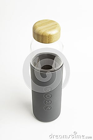 A SOMA Glass Water Bottle With Gray Silicone Sleeve Editorial Stock Photo