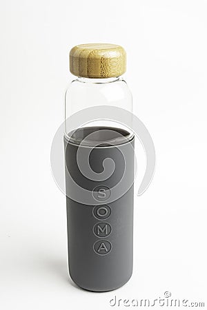 A SOMA Glass Water Bottle With Gray Silicone Sleeve Editorial Stock Photo