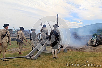 Somber view of young men firing canons during war reenactments, Fort Ticonderoga, New York, 2016 Editorial Stock Photo
