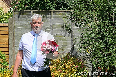 Sombre man with flowers. Condolences. Stock Photo