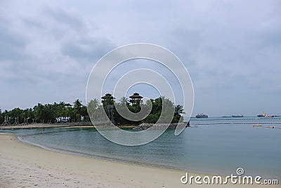 View of the small islet dubbed the Southernmost point of Continental Asia and Palawan Beach, Sentosa, with the Singapore Strait Stock Photo