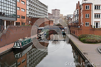 some boats docked near some buildings in the water of a canal Editorial Stock Photo
