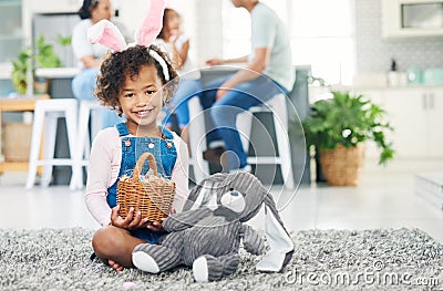 Some-bunny loves you. a young girl sitting on the floor with easter eggs at home. Stock Photo