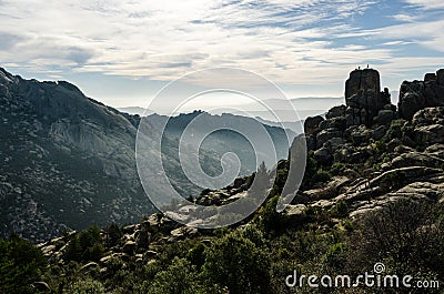 Some climbers at the very top of a rounded rock in La Pedriza Regional Park, Madrid Stock Photo