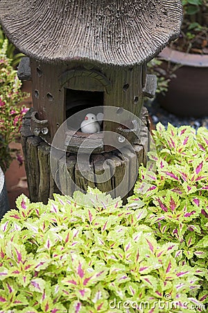 Garden decoration with little bird and birdhouse. Stock Photo