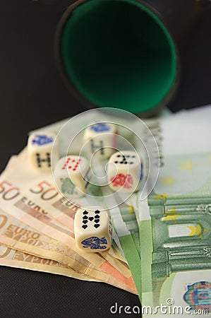 Some euro bills next to poker dice on a game table Stock Photo