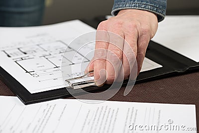 Some floorplans are clipped to a clipboard by an architect. Stock Photo