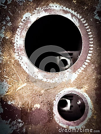 Some gear holes that look pretty chilly metalic texture abstract photograph with peeping through the other side like a key hole Stock Photo