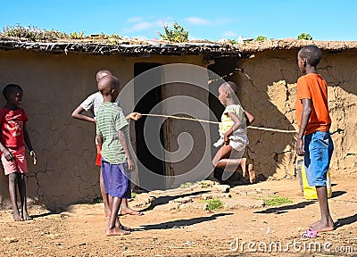 Some maasai children play jumping jacks beside their home Editorial Stock Photo