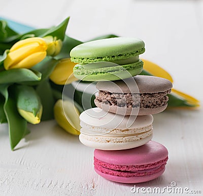 Some macaroons yellow tulips and cup of tea on the wood table spring mothers day morning Stock Photo