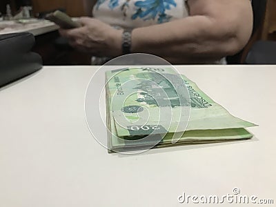 Some mexican peso money bills on a beige coloured table Stock Photo