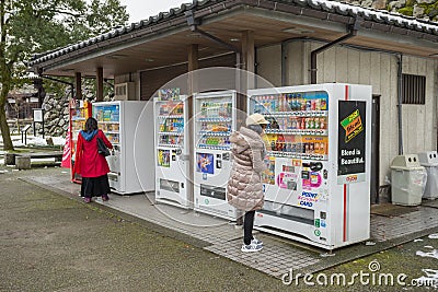 Some people buying some drink with Vending machines Editorial Stock Photo