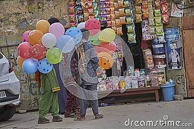 Some poor girls are selling balloons Editorial Stock Photo