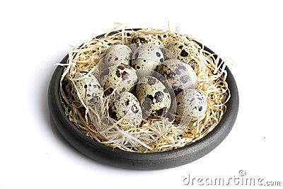 Some quail eggs in a black ceramic bowl Stock Photo