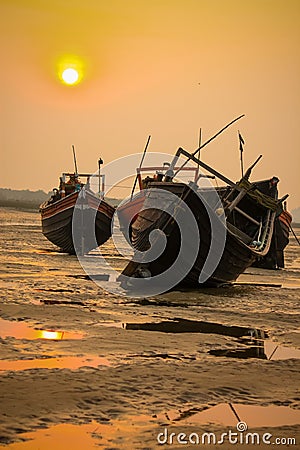 Some resting boats on the beach during sunset Stock Photo