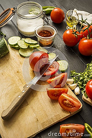 Some ripe split tomatoes together with garlic, cucumber slices, paprika Stock Photo