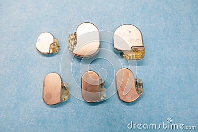 Some various pacemakers and implantable defibrilators lie on a light blue base Stock Photo