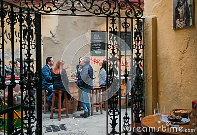 Some women and men having drinks and lunch at outdoor restaurant on old spanish street Editorial Stock Photo