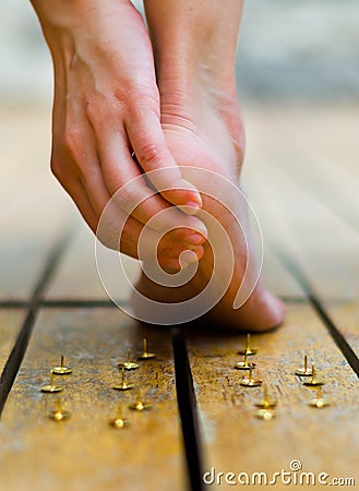 Someone get hurt with tacks, feet walked and push one of this. hand making some massage Stock Photo