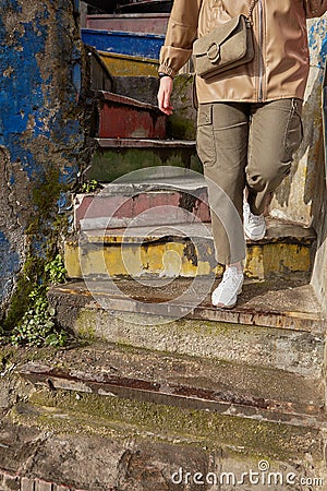 Someone goes down a spiral rainbow staircase Stock Photo