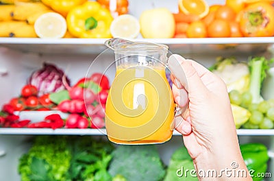 Someone picking fruit juice on full fridge Stock Photo