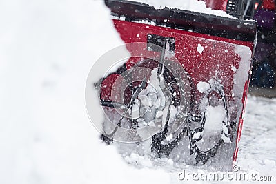 Someone uses a snowthrower outdoors in winter while it is snowing Stock Photo