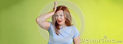 Something important slip my mind. Concerned worried upset redhead mature woman punch forehead turn away frustrated Stock Photo