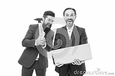 Sometimes you just have to let off steam. Crazy managers hit laptop with hammer. Brutal businessmen with crazy look Stock Photo