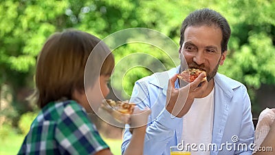 Son and father eating tasty pizza in cafe, favorite food, family weekend Stock Photo
