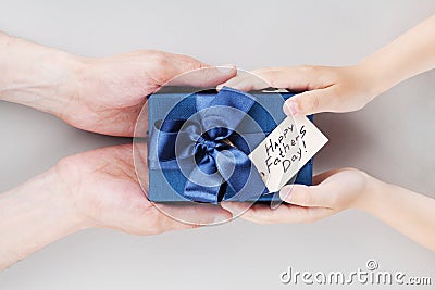 Son gives daddy present or gift box with tag on Happy fathers day. Holiday concept top view. Stock Photo