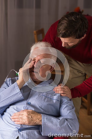 Son supporting his ill father Stock Photo