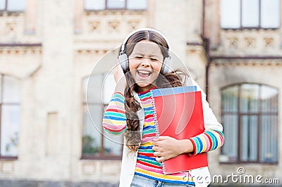 This song is a celebration of the joy. Happy little girl singing along to her favorite song. Small child enjoys school Stock Photo