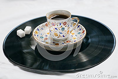Song of a morning concept. Retro sound vinyl plate and cup of coffee with sugar. Stock Photo